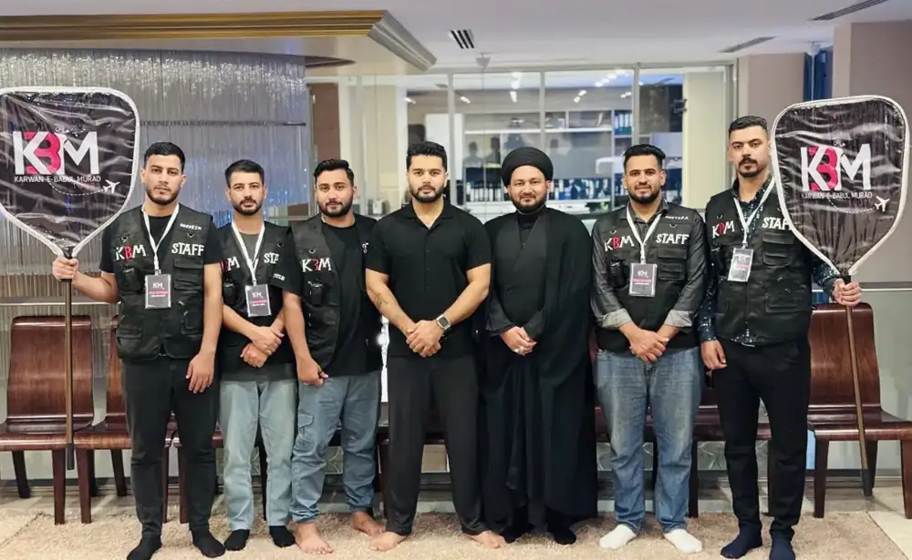 The KBM Tours staff team in black KBM Staff vests, holding KBM group signs
